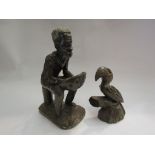 A carved stone African figure and toucan