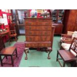 A George II revival crossbanded figured walnut chest on stand the four graduating long drawers with
