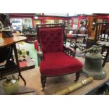 A Victorian button-back open armchair with red velour upholstery on castors,