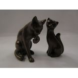 Two cat figures, one signed,