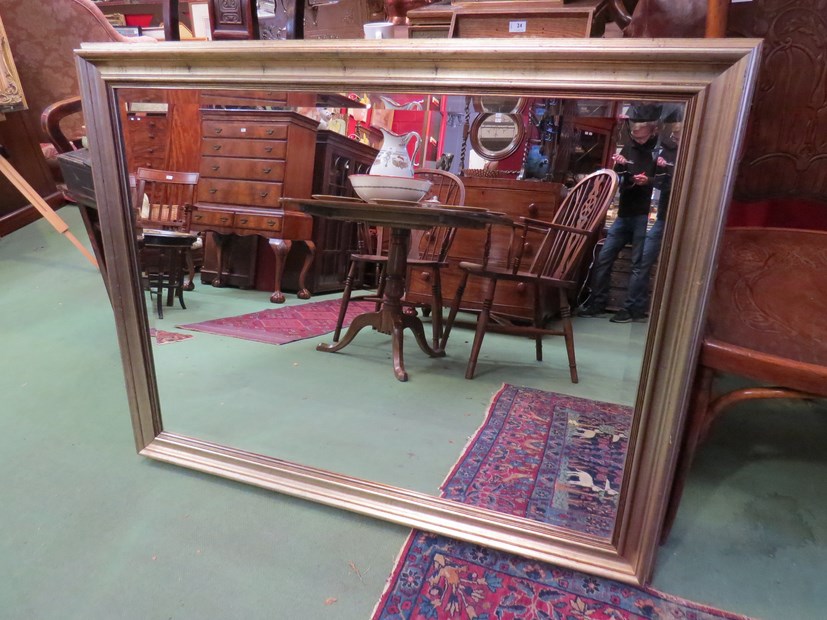 A brushed gilt wall mirror with bevelled glass,