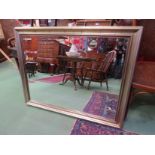 A brushed gilt wall mirror with bevelled glass,