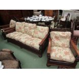 An oak three piece bergère suite with carved back rests,