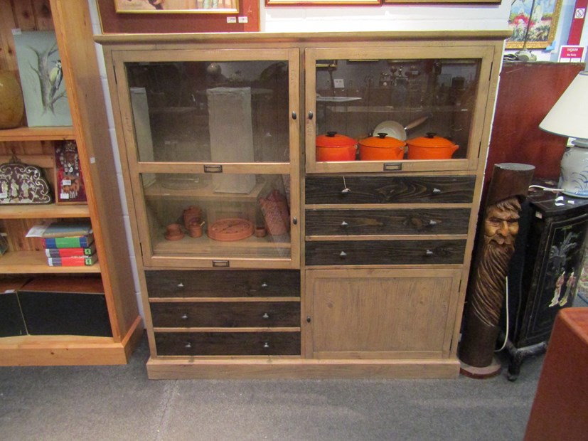 A modern hardwood cupboard with three doors and six drawers,