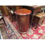 An Eastern hardwood cylindrical bedside chest with single drawer over a single door,