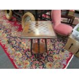 An Edwardian occasional table with chequerboard top, ring-turned supports to under-tier,