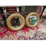 A pair of wicker framed circular mirrors