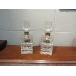 A pair of cut glass decanters with silver rims and brandy/whisky labels. Stoppers a/f.