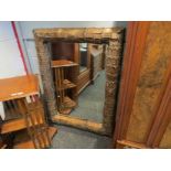 A large gilt metal feature mirror with bevelled glass,