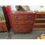 A Victorian bow fronted chest of four long drawers, bun handles, scrolled detail, turned supports,