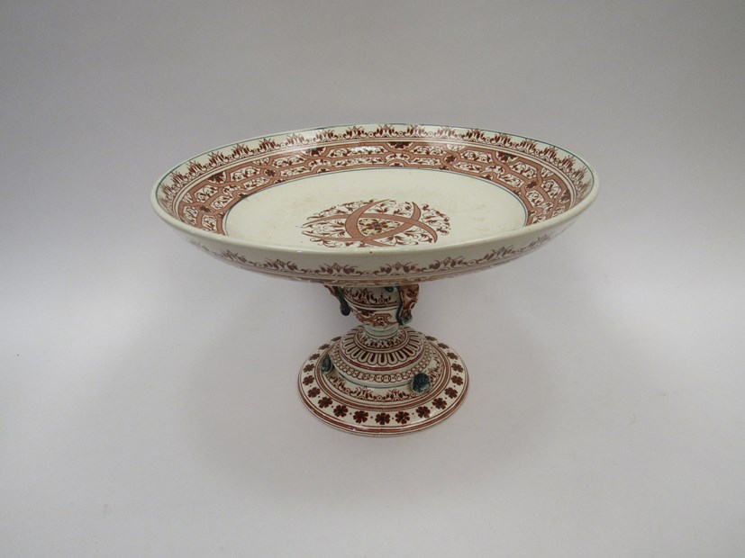 A ceramic tazza stamped Henri II Longwy with Celtic design and masked applied detail, 16.