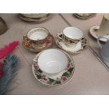 Three various floral patterned Derby porcelain tea cups with London shape handles and matching
