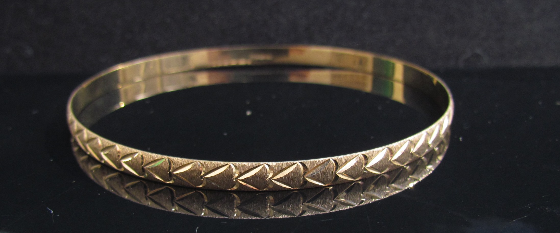 A 9ct gold engraved bangle, 6.5cm diameter, 5.5g