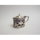 An Edwardian silver mustard pot of oval form with pierced sides and slightly domed hinged lid.