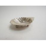 A George V silver scallop shell shaped dish raised upon three spherical feet. Birmingham 1910.