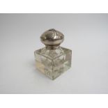 An early 20th Century German Art Nouveau square section clear glass inkwell with stylish hinged lid