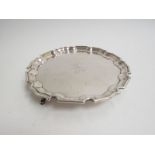 An Edwardian silver waiter in the 18th Century form, with thumb moulded pie-crust rim,