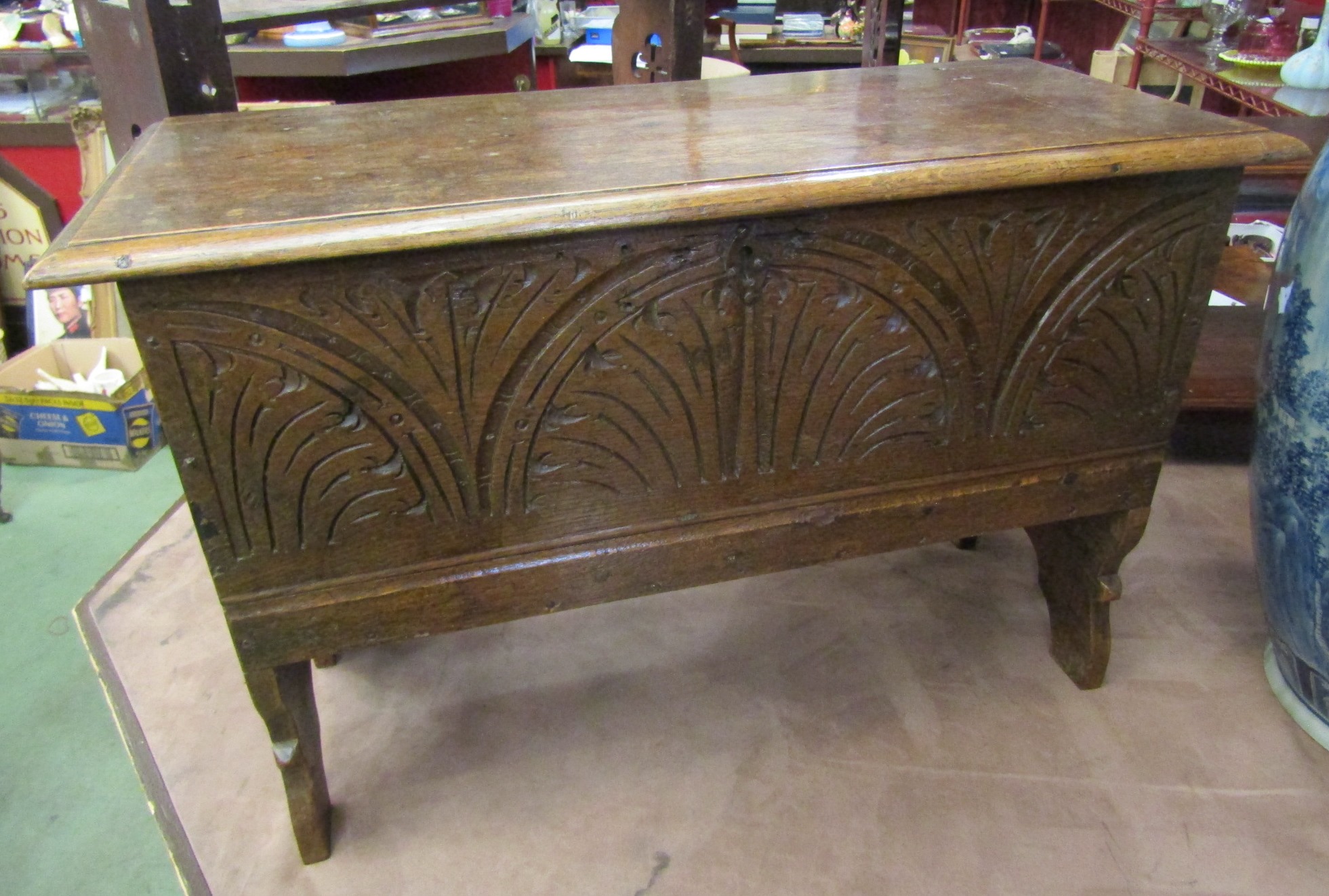 An 18th Century carved elm coffer of small proportions on shaped sides,