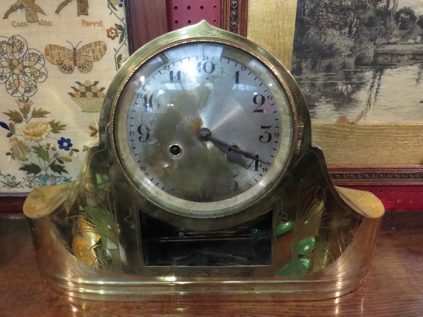 A brass cased mantel clock, engraved decoration on front.