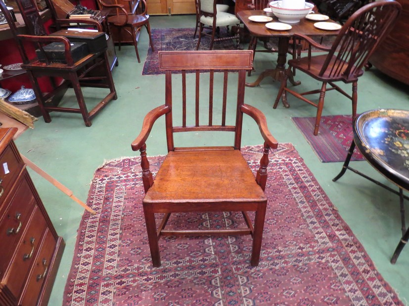 Circa 1820 an elm and oak elbow chair with reeded slab and turned arm supports,