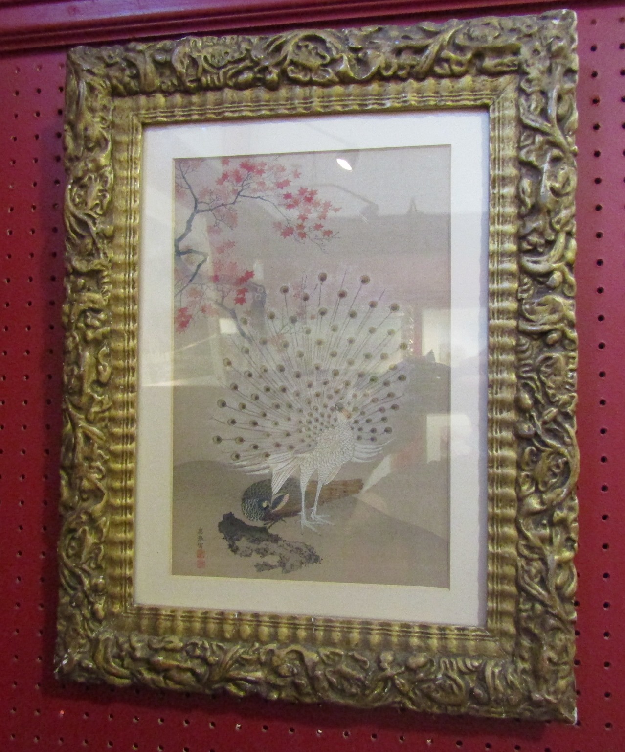 A gilt framed Oriental print of a peacock,
