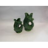 A large green glazed Dartmouth Devon pottery fish shaped glug jug and a similar smaller jug,