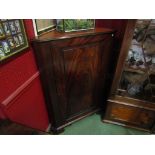 A Victorian flame mahogany floor standing corner cupboard with painted shaped shelved interior,