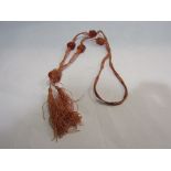 A 1920's Oriental necklace of amber coloured stone possibly jade beads on silken thread