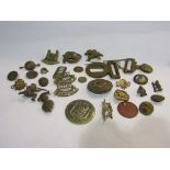 A box containing mainly WWI cap badges, buckles,