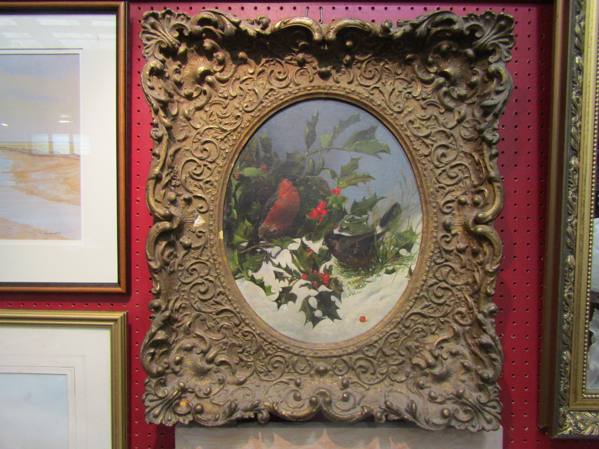 A gilt framed oil on canvas of a robin and other bird amongst holly in the snow,