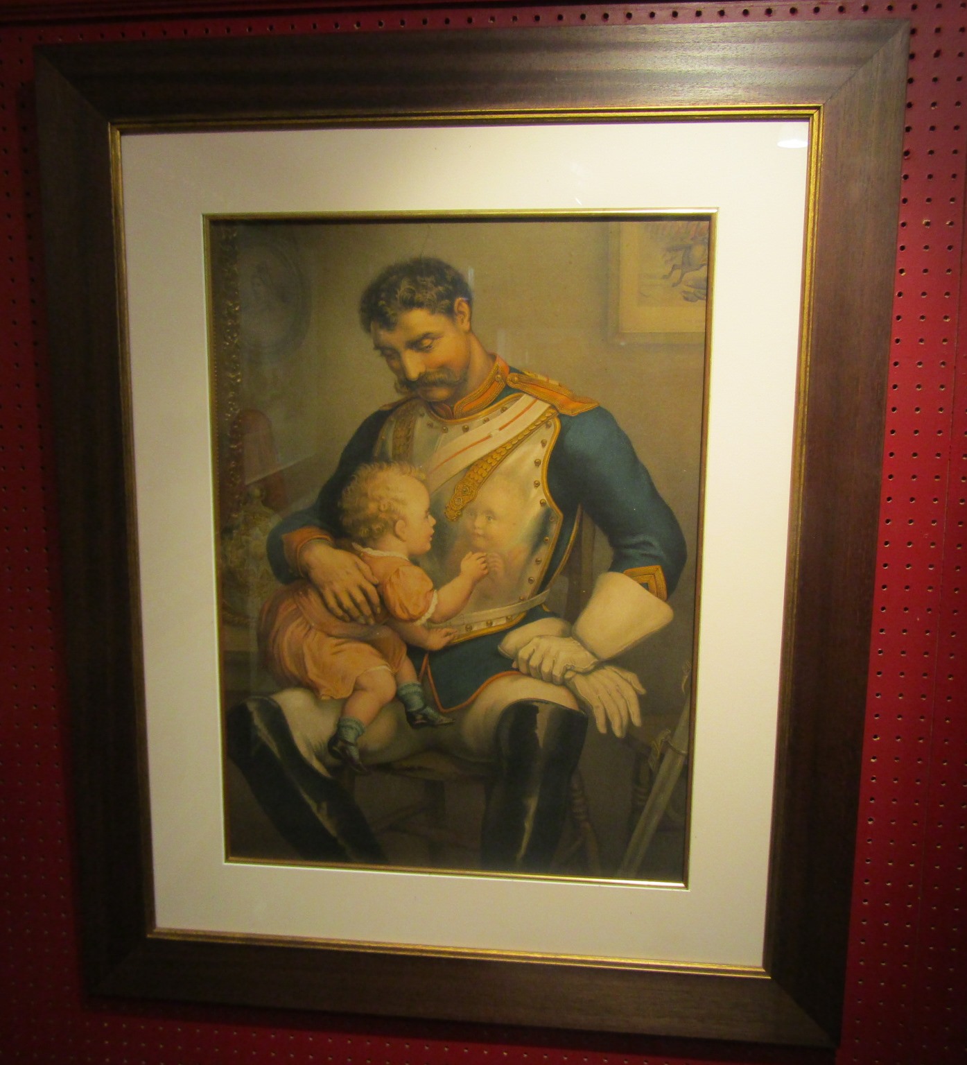 A late 19th/early 20th Century print of a soldier in armour, seated with a young child.