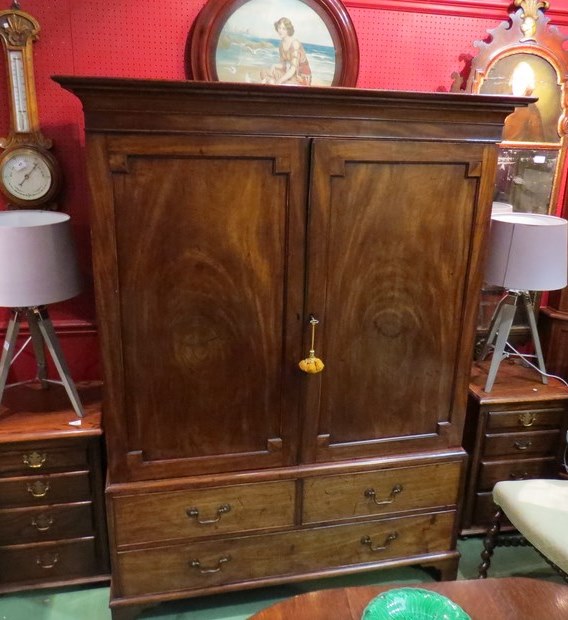 An early Victorian mahogany full hanging wardrobe the two doors over faux base drawers on bracket