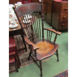 An Arts & Crafts oak high back rest elbow chair with turned spindle decoration and embossed seat on