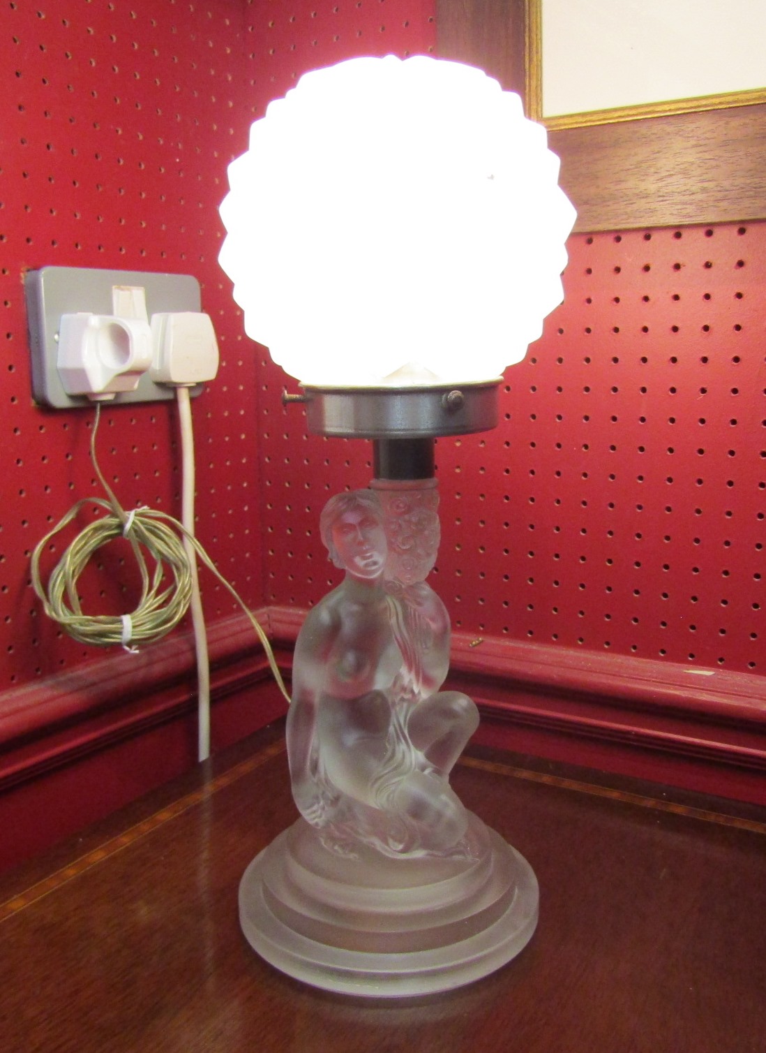 An Art Deco 1930's frosted glass lamp in the form of a kneeling lady with globular glass shade,