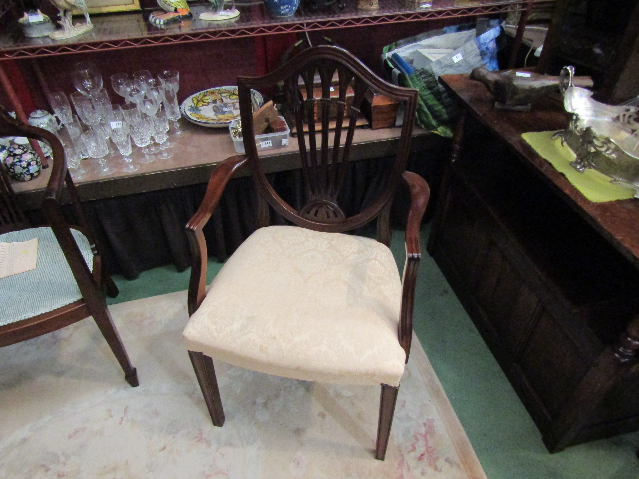 Retailed at "Harrods" a George III style mahogany shield-back elbow chair on square tapering legs