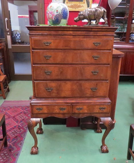 A George II revival crossbanded figured walnut chest on stand the four graduating long drawers with