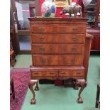 A George II revival crossbanded figured walnut chest on stand the four graduating long drawers with