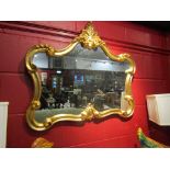 A modern ornately gilt framed wall mirror,