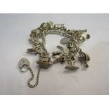 A silver charm bracelet with multiple charms including Poodle, wagon and dog in kennel, 91.