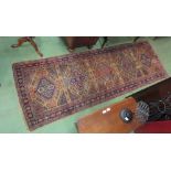 A wool runner with five central lozenges, beige ground and multiple borders, 257cm x 89cm, a/f,