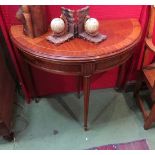 A George III revival inlaid mahogany demi-lune games table the tooled leather inset over reeded