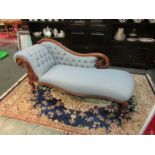 A Victorian mahogany framed chaise longue with carved seat rail and ornately carved scrolls to head
