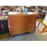 A 1960's teak dining sideboard, fall flap and twin cupboard doors with fitted interior,