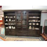 A full height three section bookcase, the central two door glazed cabinet over two panelled doors,