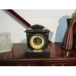 A black slate mantel clock with a brass personal inscription plaque,