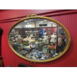 A late 19th Century oval wall mirror with bevelled glass