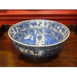 An early 20th Century blue and white Oriental bowl with figural and floral scenes,