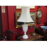 A resin classical style table lamp base with scenes of putti and cream fluted shade