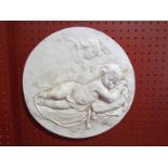 A plaster circular wall plaque depicting cherubs,