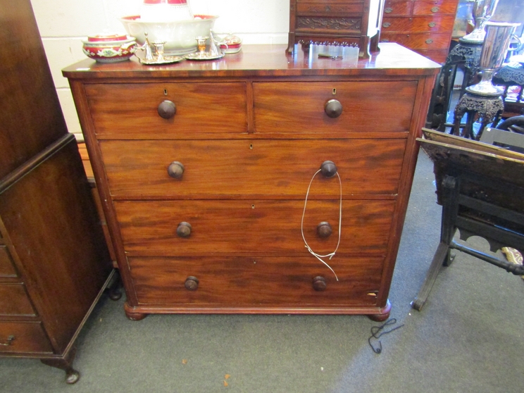 A Victorian mahogany round-cornered chest of two short over three long drawers, bun handles,